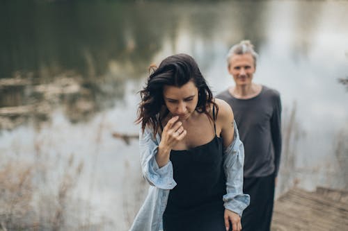 Calm woman walking with boyfriend near pond