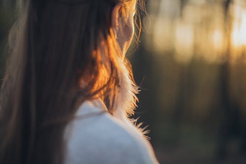 Young woman standing in nature during sunset
