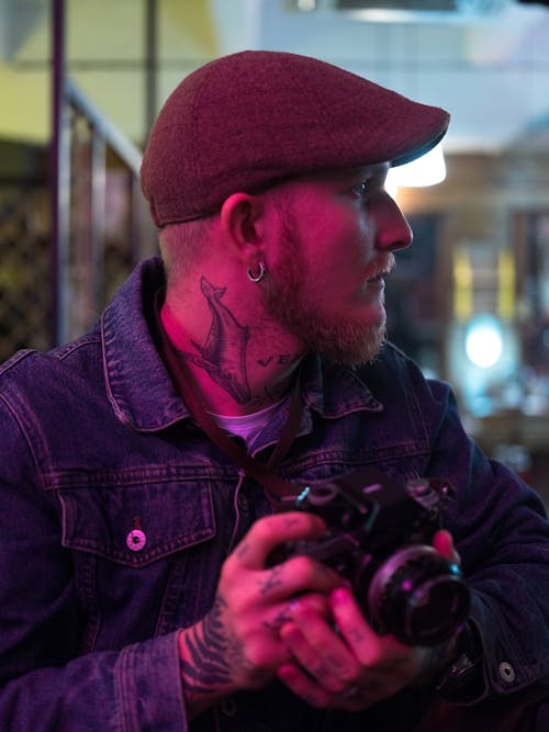 Man in Denim Jacket Holding Black Dslr Camera