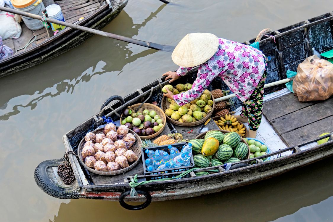 Photo of Person Selling Fruits While Standing on Boat
