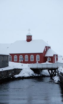 教堂建筑坐落在冷河岸边，靠近冬季桥，被雪覆盖