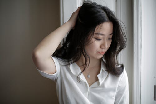 Young Asian woman touching hair