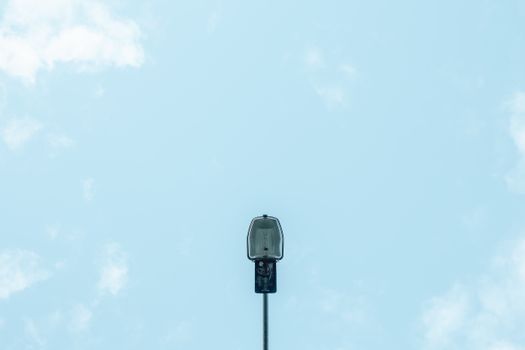 From below modern streetlight located against cloudy blue sky on sunny day in city
