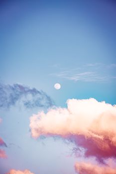 淡淡的云彩与满月高悬于充满活力的蓝天之下，构成了一幅宁静的景色，营造出安详的氛围