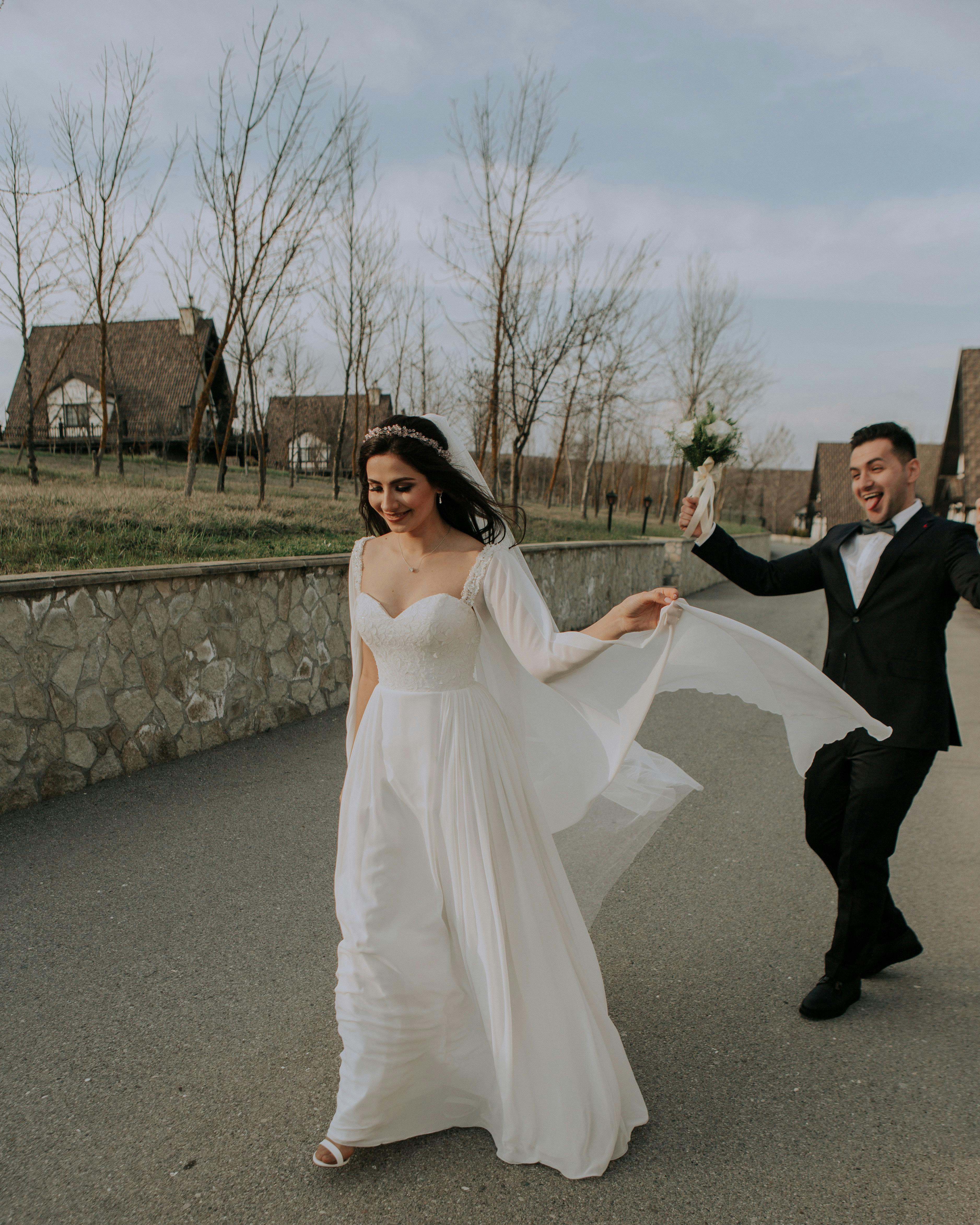 happy newlywed couple walking on street