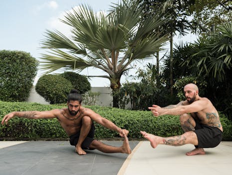 Two men in a garden performing yoga poses outdoors, showcasing flexibility and fitness.