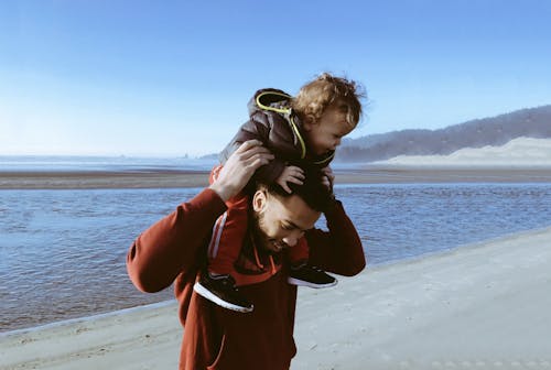 Безкоштовне стокове фото на тему «батько та дитина, біля моря, веселощі»
