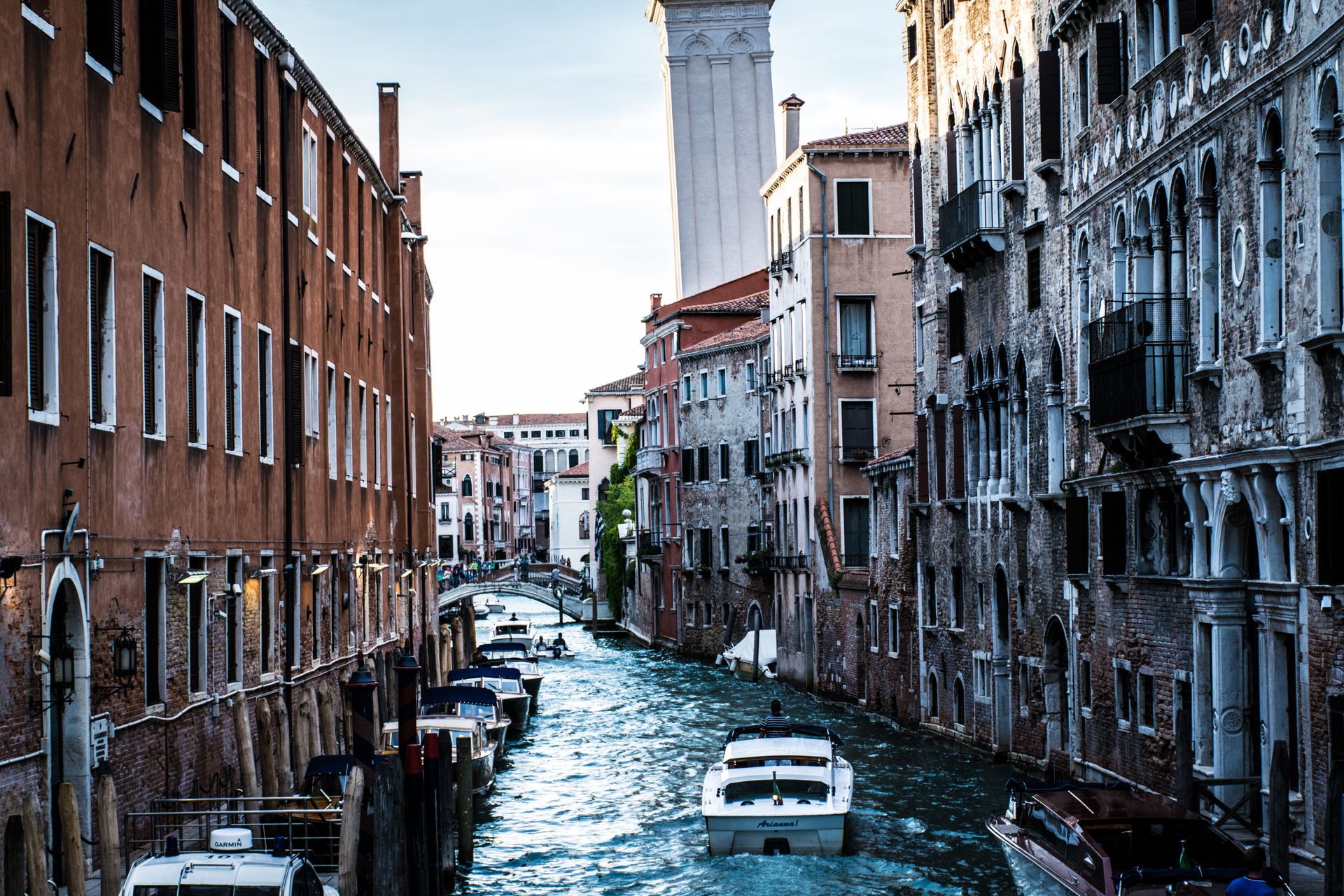 Charming Venetian canal scene with boats navigating between historic buildings in Venice, Italy.