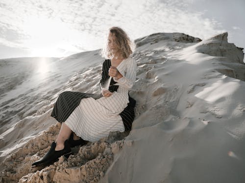 Woman sitting on sand in desert