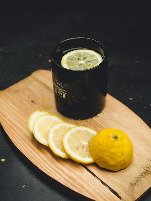 Cutting Board with a Mug and a Sliced Lemon