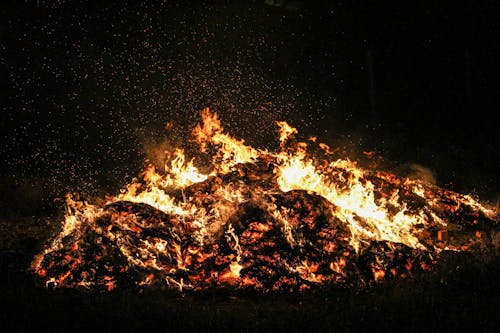 Burning bonfire with sparkles in darkness