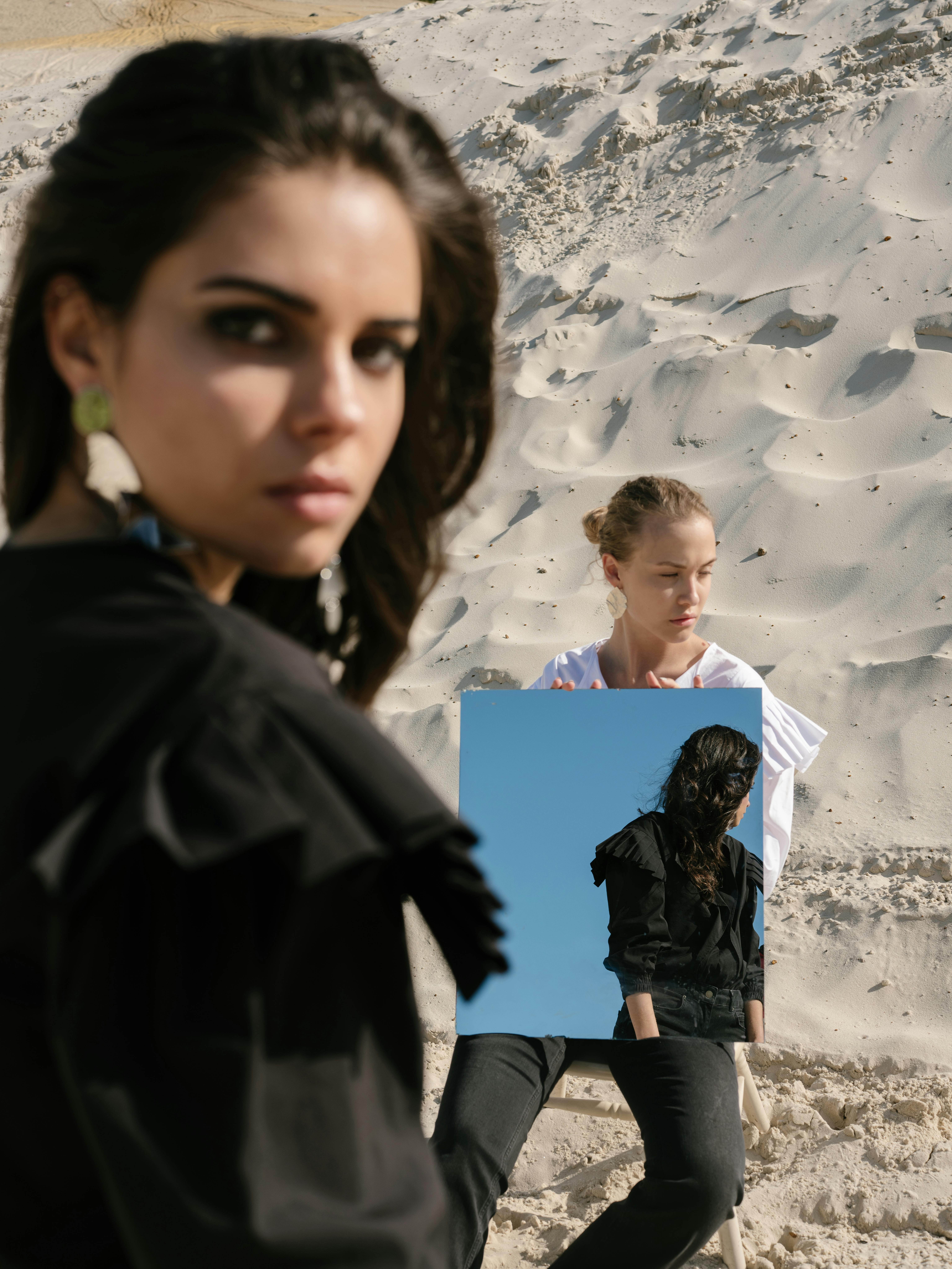 Female rivals with mirror on sandy beach · Free Stock Photo