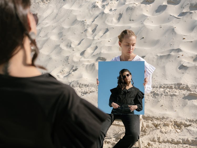 Young Female Rivals With Mirror On Sandy Beach In Daytime