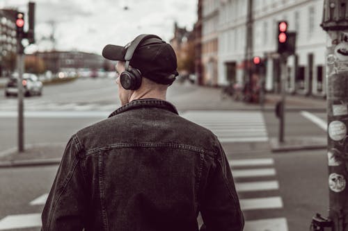 Free Man listening to music on city street Stock Photo