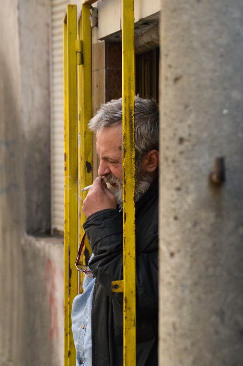Free An elderly man thoughtfully smoking in an urban setting in Belgrade, Serbia. Stock Photo