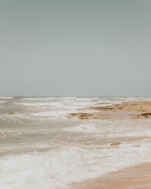 Free Waving sea washing peaceful sandy shore Stock Photo