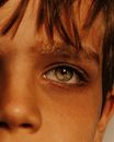 Closeup crop face of calm thoughtful boy with fathomless gray green eyes and bangs