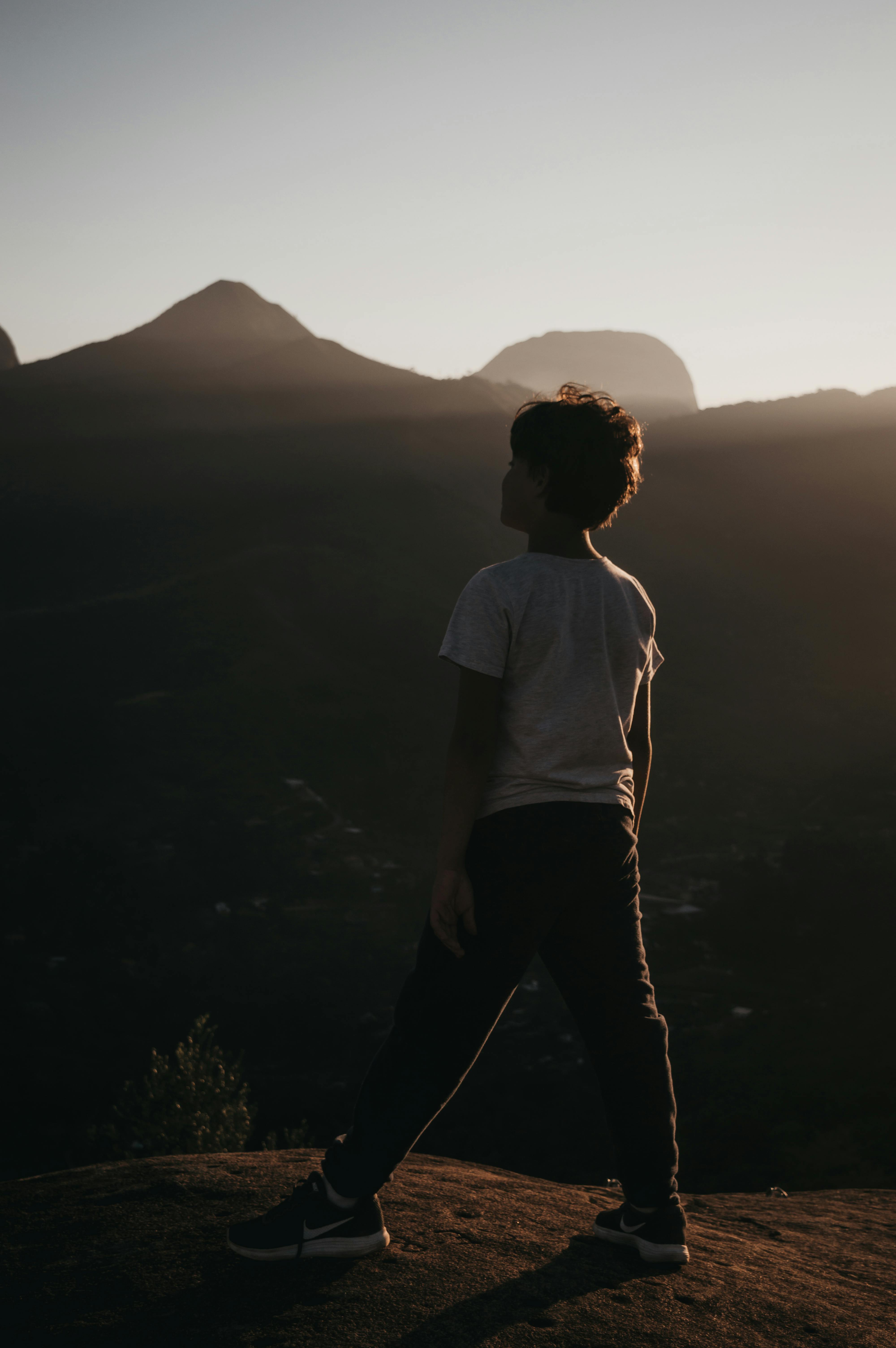 Unrecognizable boy admiring mountainous landscape in highlands · Free Stock Photo