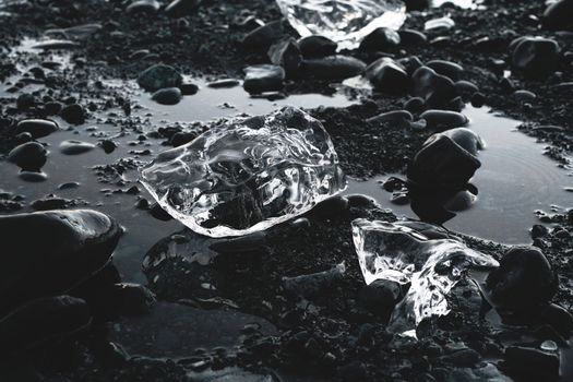 Pieces of ice on rocky ground with water
