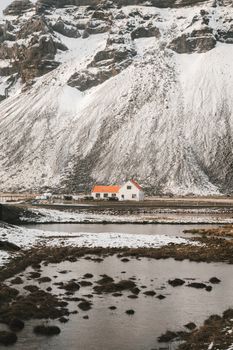 风景如画，远处的小屋坐落在乡村的湖泊与雪山之间，白天里一片宁静祥和
