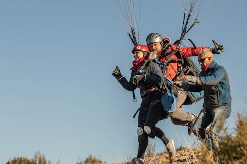 Free Instructor helping paragliders to take off Stock Photo