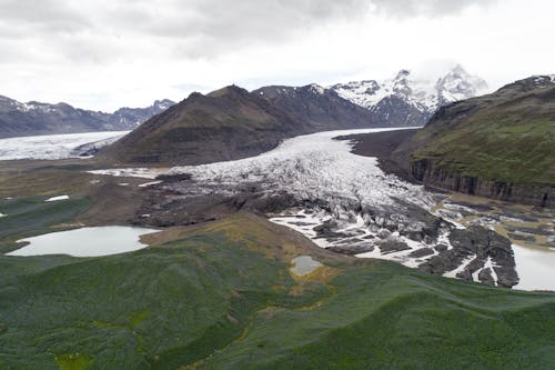 Picturesque scenery of mountainous terrain with green hills and snowy peaks