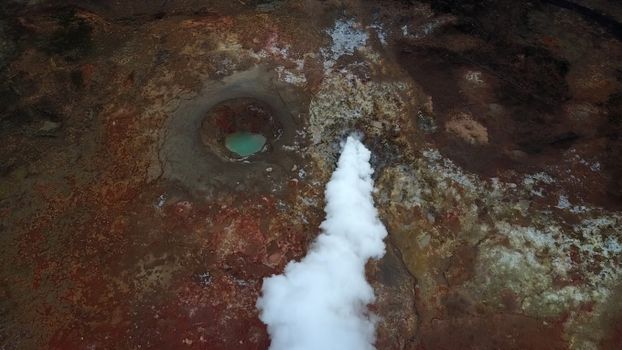 Volcanic terrain with steaming fumarole and mud pool