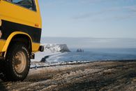 Car parked on hill against endless ocean in winter