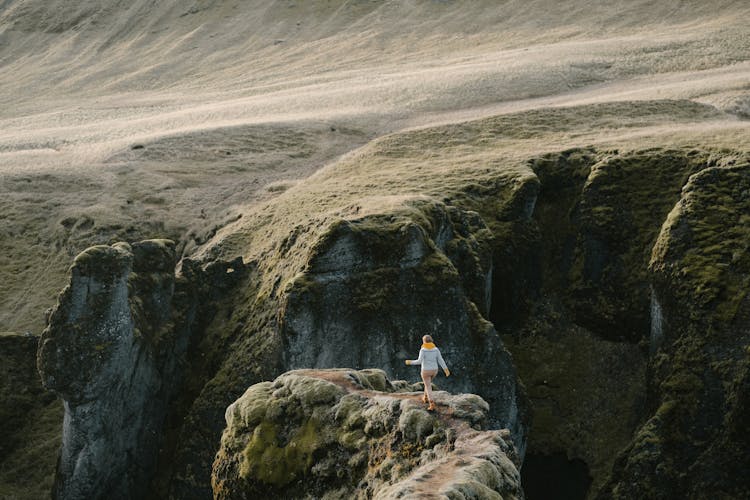 Person Walking Near Cliffs