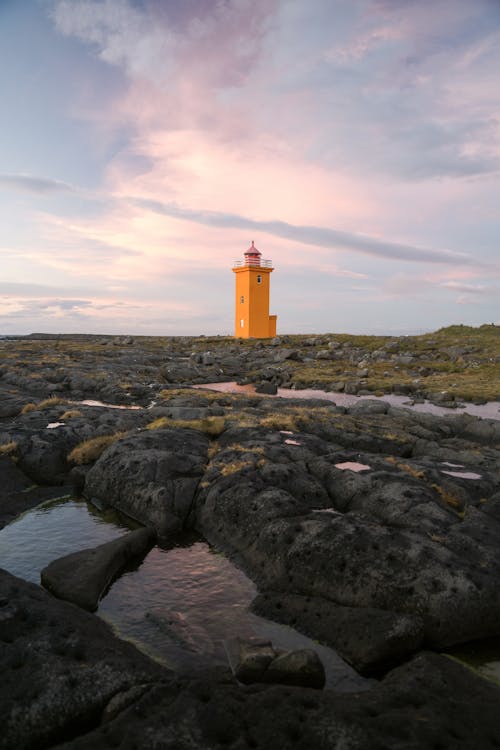 Orange beacon on seashore in daytime