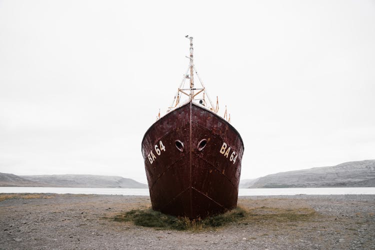 Aged Ship Stranded On Sandy Coast Near Serene River