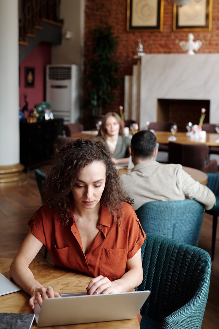 Woman Using A Laptop At The Restaurant