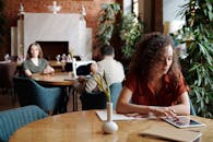 一位女士在时尚的咖啡馆里用平板电脑进行远程工作