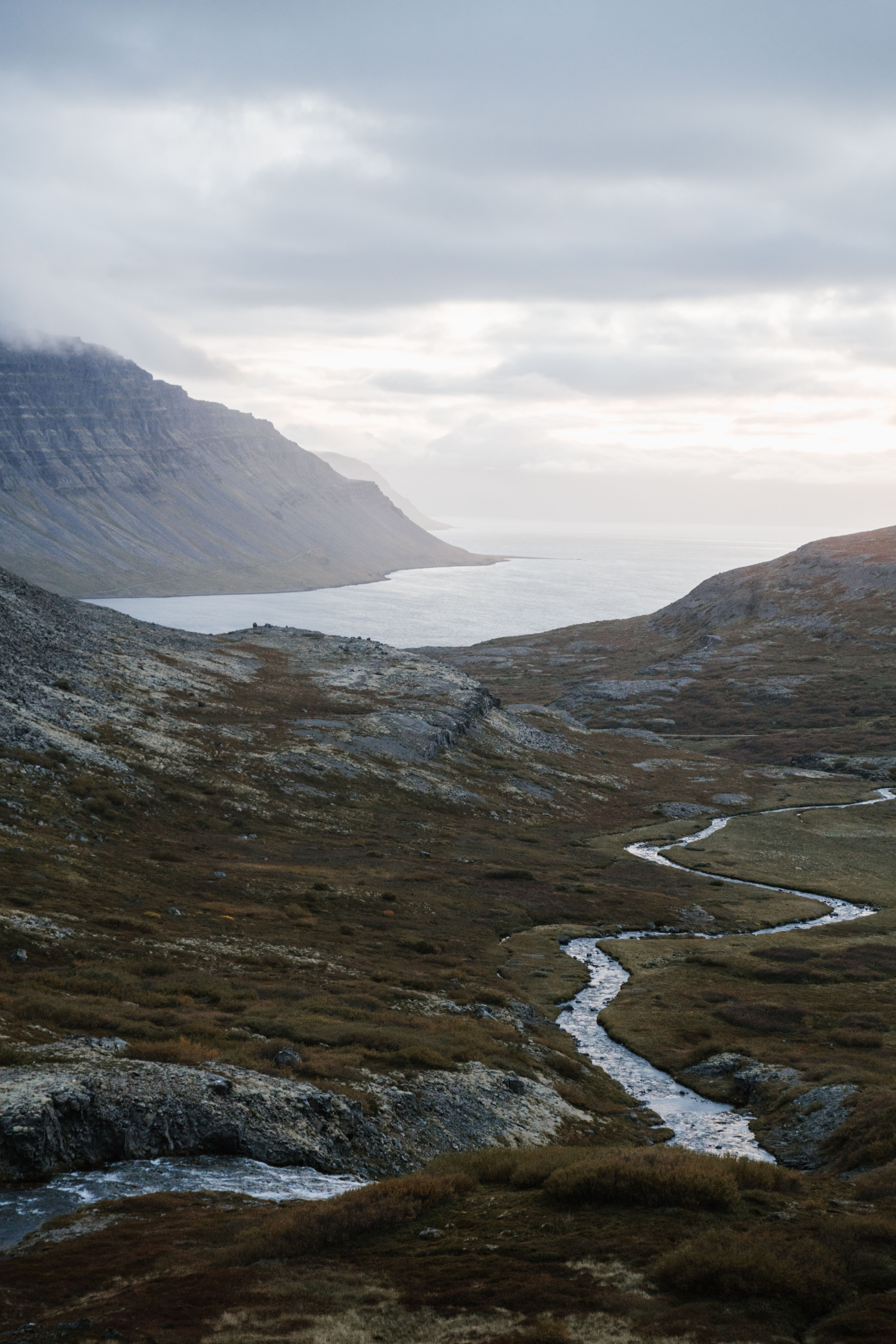 Ocean surrounded by mountains and river tributaries under cloudy sky ...