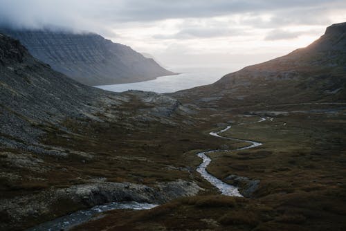 River inflows passing between mountains near big lake in mist