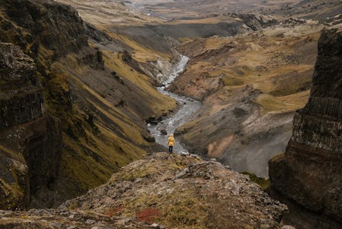 A Person Standing on a Cliff Overlooking the Landscape Scenery