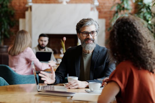 Business professionals having a discussion over coffee in a modern cafe setting.