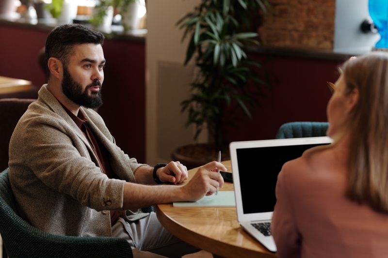 Two people reviewing work on a laptop in a cafe &mdash; photo by Edmond Dantès on Pexels