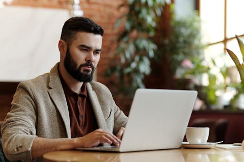 Free Man Using Laptop in the Restaurant Stock Photo