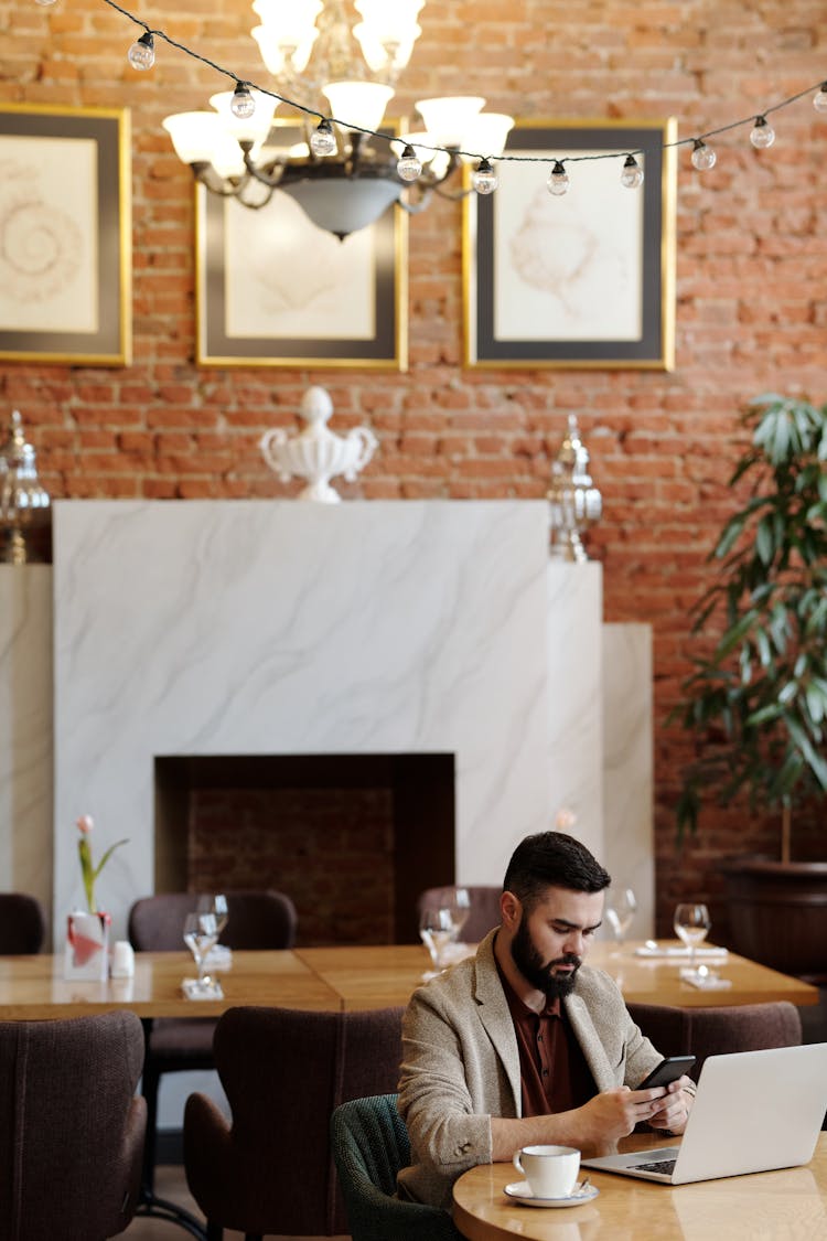 Bearded Man Using A Cellphone At The Restaurant