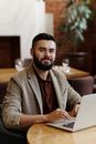 Man Sitting by the Table Using Computer Laptop