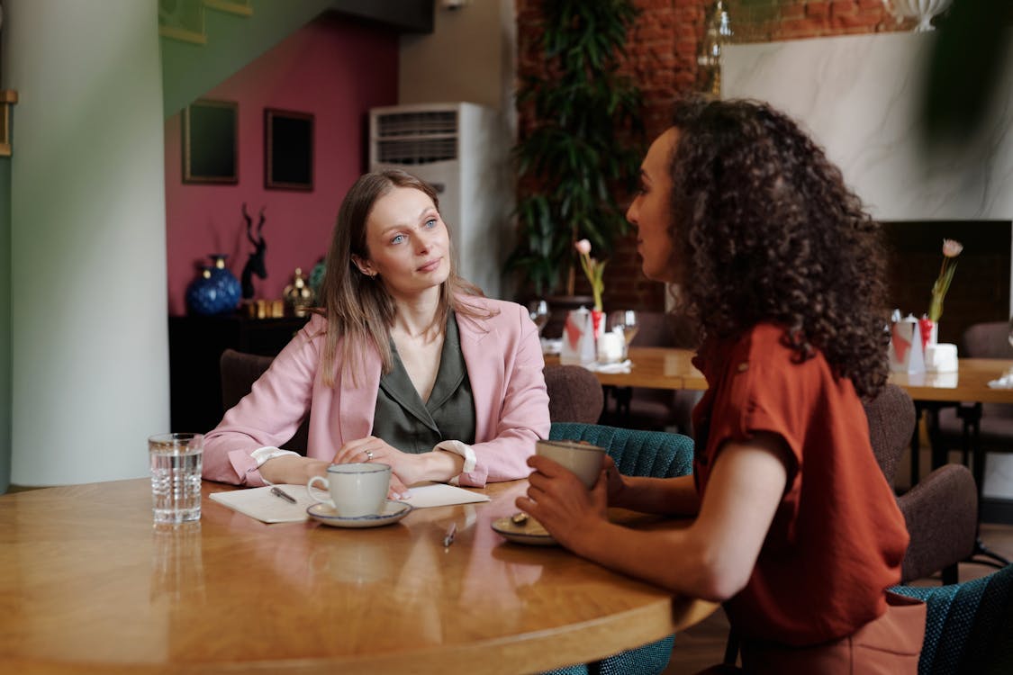 Women Sitting at the Table Drinking Coffee