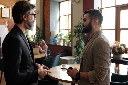 Free Two bearded men engage in a professional conversation in a stylish cafe interior. Stock Photo