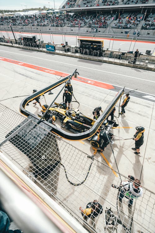 Professional mechanics at pit stop servicing racing car