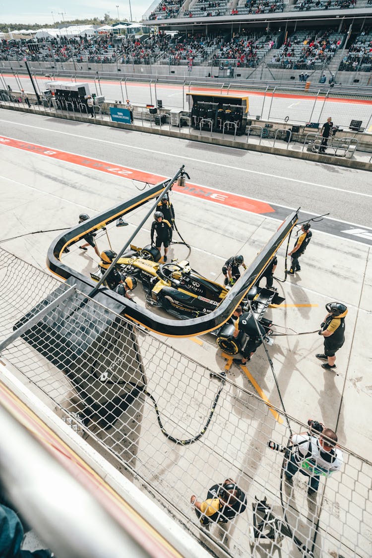 Professional Mechanics At Pit Stop Servicing Racing Car