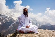 A Man in White Thobe Meditating on the Mountain Top