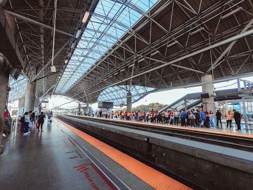 Crowd of people standing on platform of railway station and waiting train in busy day