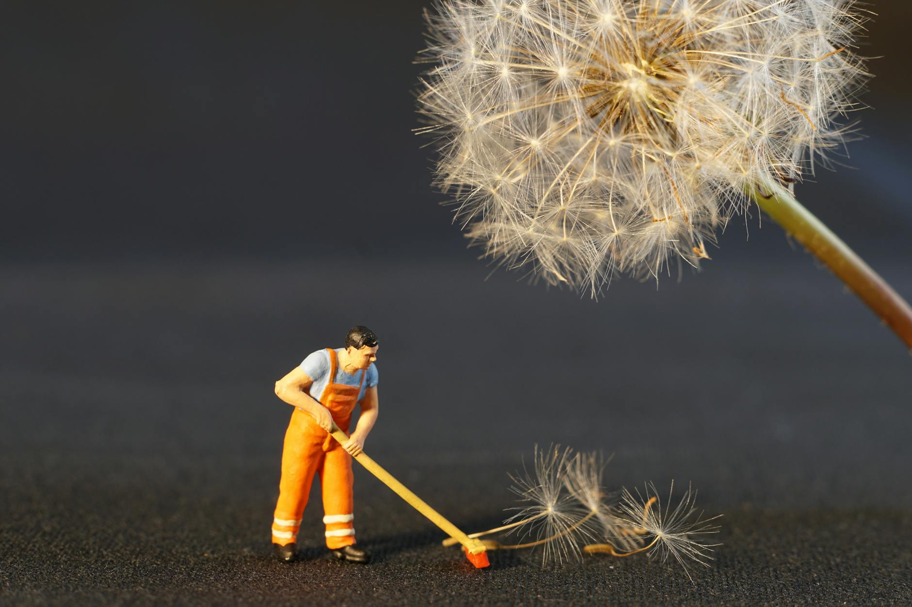 Shallow Focus Photo of Man Holding Floor Brush Ceramic Figurine