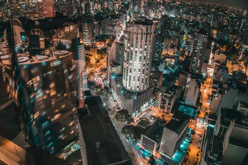 Free An aerial view of a bustling city at night showcasing illuminated skyscrapers and vibrant lights. Stock Photo