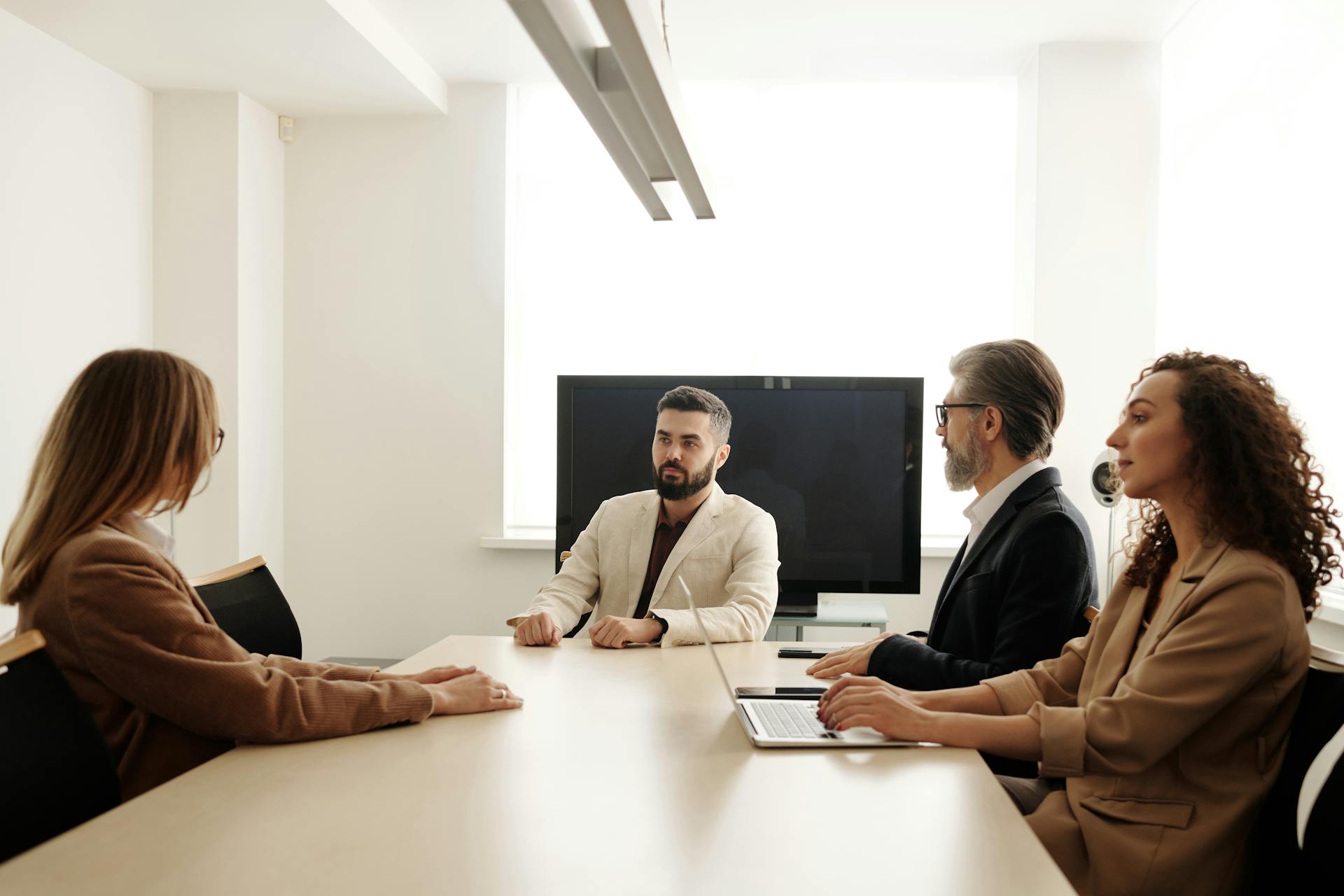 A group of professionals discussing strategy in a bright modern office setting.